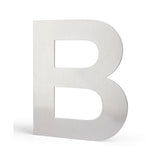 Une grande lettre B en métal avec une finition lisse et brossée se dresse sur un fond blanc uni, reflétant le design élégant de l'Adamo Stainless Steel 20cm de yessential.fr.