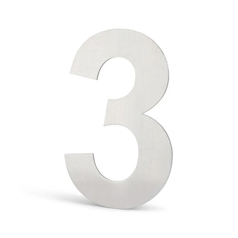 Un grand chiffre 3 métallique avec une finition argent brossé se tient debout sur un fond blanc. Cet élégant numéro de maison Animo en acier inoxydable de 15 cm (sans perçage) de yessential.fr est parfait pour les maisons contemporaines.