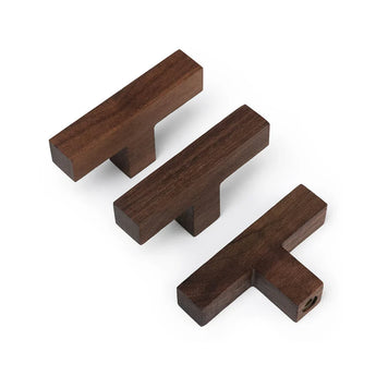 Trois boutons Vigio en noyer de yessential.fr en brun foncé sur fond blanc. Les boutons en bois en forme de T sont placés à différents angles pour mettre en valeur le design élégant et la qualité de l'artisanat.