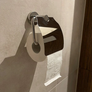 Un rouleau de papier toilette est suspendu au porte-rouleau de papier toilette Julio Chrome avec couvercle de yessential.fr, le couvercle brillant reflète la salle de bain carrelée et rehausse le look moderne avec des accessoires de toilette élégants.