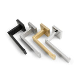 Quatre poignées de porte modernes et rectangulaires Vero Gold Deluxe de yessential.fr sont alignées sur une surface blanche. Ces accessoires de salle de bain luxueux sont disponibles en noir, argent, or et argent brossé avec un design élégant et minimaliste.