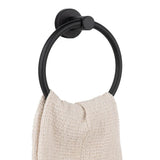 Une texture de serviette beige est suspendue au-dessus des serviettes Elarbo Black de yessential.fr, fixées sur un mur blanc - une solution élégante et encombrante pour toute la salle de bain.