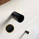 Un gros plan d'un bouton Remo Black Deluxe de yessential.fr sur un boîtier blanc, avec un encart mettant en valeur la surface moletée détaillée du bouton moderne.