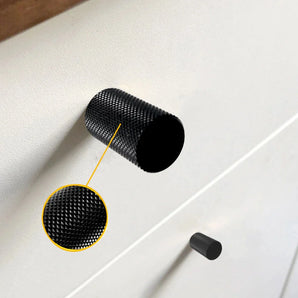 Un gros plan d'un bouton Remo Black Deluxe de yessential.fr sur un boîtier blanc, avec un encart mettant en valeur la surface moletée détaillée du bouton moderne.
