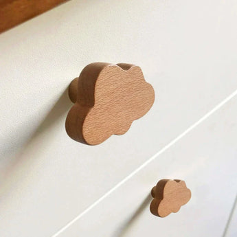 Gros plan d'une commode blanche avec des boutons Bambino Cloud de yessential.fr - des boutons de tiroir en bois en forme de nuages ​​ajoutent une touche ludique et fantaisiste, rendant ces pièces parfaites pour la chambre de bébé.