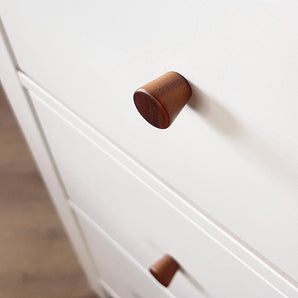 Gros plan d'une armoire de couleur claire avec des boutons en noyer Salgado de yessential.fr. L'accent est mis sur le bouton rond supérieur, avec un autre en dessous.