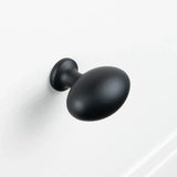 Un Agero Black Knob Deluxe noir mat de forme ovale de yessential.fr est monté sur une surface blanche.