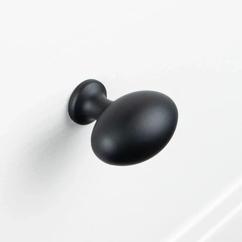 Un Agero Black Knob Deluxe noir mat de forme ovale de yessential.fr est monté sur une surface blanche.