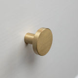 Monté sur une surface plane gris clair ou blanche, le bouton rond en laiton brossé Marizo Gold de yessential.fr apporte une sophistication élégante à n'importe quelle pièce.