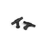 Deux boutons Cordero Black de yessential.fr avec une finition noire mate sont présentés sur une surface blanche : l'un tient debout, l'autre repose à plat pour que la base ronde soit visible.