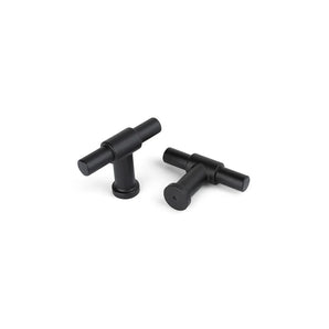 Deux boutons Cordero Black de yessential.fr avec une finition noire mate sont présentés sur une surface blanche : l'un tient debout, l'autre repose à plat pour que la base ronde soit visible.