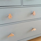 Le Bambino Dolphin de yessential.fr est une commode bleu clair avec des boutons en forme de pingouin sur le tiroir supérieur et un bouton en bois représentant un dauphin en dessous, ce qui en fait un accent ludique pour n'importe quelle chambre d'enfant.