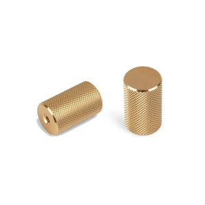 Deux boutons Remo Gold Deluxe de yessential.fr - une paire de boutons cylindriques en laiton avec des surfaces moletées texturées, l'un avec un trou et l'autre vertical avec un dessus lisse - présentés sur fond blanc.