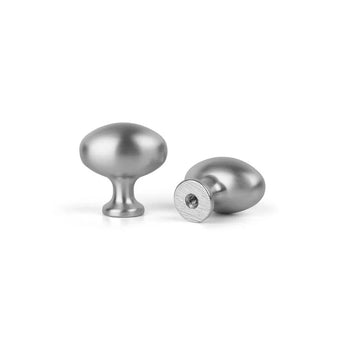 Deux boutons d'armoire yessential.fr Agero en acier inoxydable de luxe sont représentés sur un fond blanc uni - un droit avec un dessus arrondi et un couché sur le côté avec le trou de vis.