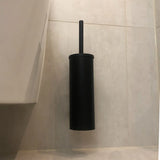 L'ensemble WC Lorenzo Black de yessential.fr, avec porte-brosse de toilette et poignée noirs, est fixé sur un mur carrelé de couleur claire à côté des toilettes - parfait pour compléter avec style vos accessoires de salle de bain noir mat.