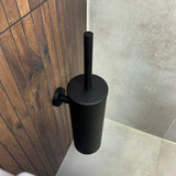L'ensemble WC Lauro Black de yessential.fr présente un design cylindrique noir mat élégant - ce support de toilette mural se marie parfaitement avec du bois foncé et des carreaux beiges pour un ensemble d'accessoires de salle de bain sophistiqué.