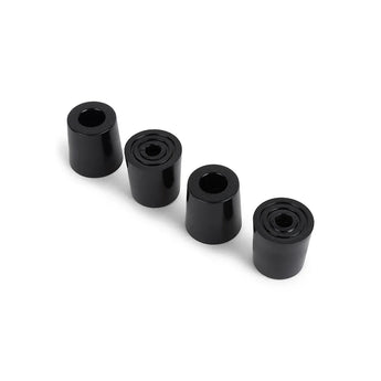 Quatre pieds cylindriques en caoutchouc noir avec trous centraux, placés en diagonale sur fond blanc - parfaits pour augmenter la stabilité de votre boîte aux lettres Nevio Anthracite de yessential.fr ou de toute autre boîte aux lettres moderne.