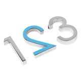 Trois numéros adhésifs Silvio Chrome 60 mm de yessential.fr - numéros 1 (argent), 2 (bleu avec contour argenté) et 3 (argent) - avec support adhésif, sont placés à plat et étroitement espacés sur une surface blanche.