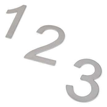 Trois chiffres métalliques argentés (1, 2 et 3), légèrement inclinés et placés en diagonale sur un fond blanc, représentent les numéros de maison Animo en acier inoxydable de 7,6 cm (sans perçage) de yessential.fr - montage élégant sans perçage.