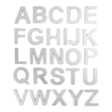 Les lettres majuscules métalliques Animo de 5 cm (sans perçage) en acier inoxydable de yessential.fr se présentent sur cinq rangées sur un fond blanc, avec un design moderne et élégant en acier inoxydable - parfaites comme numéros de maison autocollants.