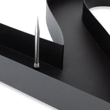 Gros plan d'Angelo Black 30 cm de yessential.fr - une surface en métal noir avec un bord courbé et une pointe argentée, idéale pour accrocher des numéros de maison modernes ou pour ajouter des numéros de maison 3D élégants à votre écran.