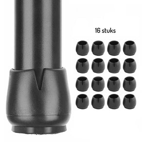 Gros plan d'un pied de meuble noir avec un capuchon de protection en silicone Paco Set Ø 17-21 mm de yessential.fr, à côté de 16 capuchons anti-rayures identiques sur quatre rangées, étiquetés 16 pièces.