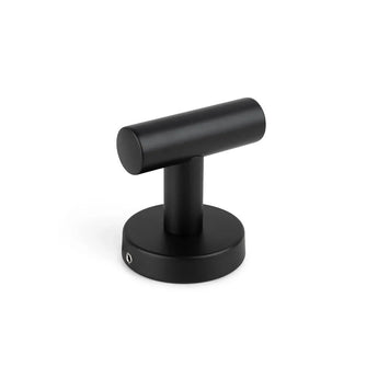 Un butoir de porte cylindrique noir mat en forme de T avec une base ronde et un design minimaliste, parfaitement combiné avec l'ensemble WC Sandro Black de yessential.fr, présenté sur fond blanc.