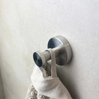 Une murale au crochet Santino et un pour WC plus inoxydable de yessential.fr maintiennent avec une texture de serviette beige sur la boucle avec un clair et une utilisation de la fonction élégante de la collection d'accessoires de toilette.