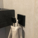 Le grand plan au crochet bleu utilisé par yessential.fr utilise une texture de serviette beige, montée sur la paroi du lavabo au-dessus du lavabo.