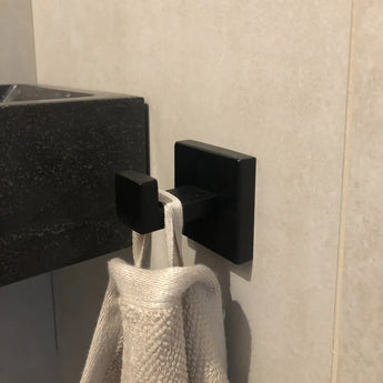 Le grand plan au crochet bleu utilisé par yessential.fr utilise une texture de serviette beige, montée sur la paroi du lavabo au-dessus du lavabo.