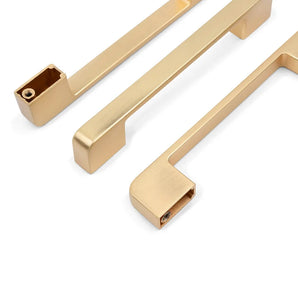 Trois poignées Ramiro Gold Deluxe de yessential.fr se trouvent sur un fond blanc, deux plates et une inclinée pour montrer le trou de montage.