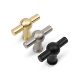 Trois boutons Rando en acier inoxydable de yessential.fr en or, argent et noir sur fond blanc. Chacun possède une poignée cylindrique en forme de T reliée à une base ronde.