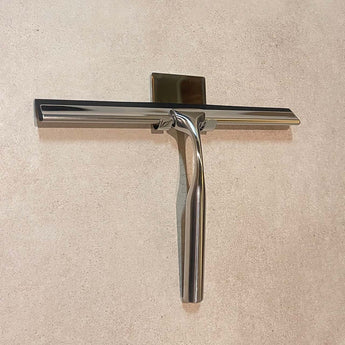 La Zamoro Chrome de yessential.fr est une raclette élégante et moderne fabriquée en acier inoxydable durable avec un système de montage mural 3M, montée sur une surface texturée beige clair pour un style et une fonctionnalité durables.