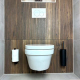 Une salle de bains moderne avec des toilettes murales blanches, un mur en panneaux de bois, des boutons de double chasse noir mat au-dessus, un porte-papier toilette à gauche et l'ensemble de toilettes Donato Black de yessential.fr avec les accessoires assortis à droite.