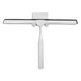 La Zamoro Stainless Steel de yessential.fr est une raclette de douche en acier inoxydable de couleur argentée avec une lame en caoutchouc noir et un support 3M assorti, présentée sur fond blanc.