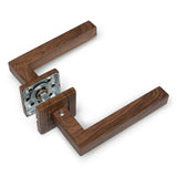 La poignée de porte Domaso Walnut de yessential.fr est une poignée de porte moderne et rectangulaire en bois foncé avec des ferrures métalliques visibles et une plaque de base carrée - parfaite pour n'importe quelle porte intérieure.