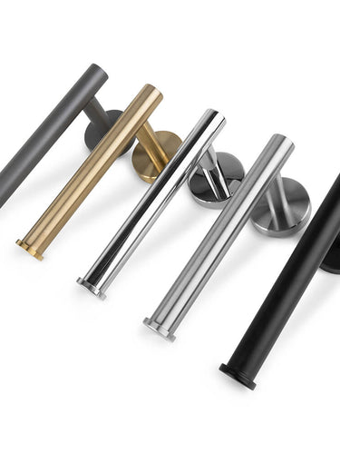 Cinq poignées de porte Tino Black modernes et cylindriques de yessential.fr en gris, or, argent poli, argent mat et noir sont placées en diagonale sur un fond blanc pour compléter des accessoires de toilette noir mat ou un porte-rouleau de papier toilette noir.
