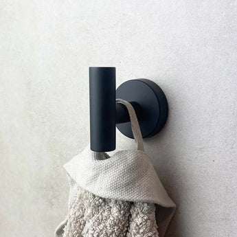 Le crochet noir Rodrigo de yessential.fr utilise principalement une serviette beige avec une texture de couleur claire. Le design cylindrique moderne allie une touche élégante au service principal avec une boucle et une portée de main.