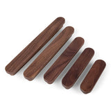 Quatre manches en bois de noyer Arriero lisse et ovale de yessential.fr de différentes longueurs sont disposés en diagonale du plus grand au plus petit sur un fond blanc.