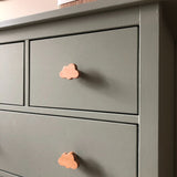 Gros plan d'un buffet vert sauge avec bouton de meuble en bois Bambino Cloud de yessential.fr dans un design nuage ludique. La finition lisse et mate et les lignes simples le rendent parfait pour une chambre de bébé minimaliste et joyeuse.