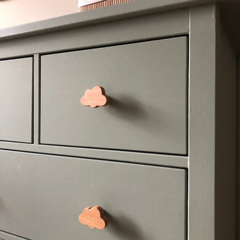 Gros plan d'un buffet vert sauge avec bouton de meuble en bois Bambino Cloud de yessential.fr dans un design nuage ludique. La finition lisse et mate et les lignes simples le rendent parfait pour une chambre de bébé minimaliste et joyeuse.