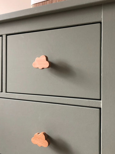 Gros plan d'un buffet vert sauge avec bouton de meuble en bois Bambino Cloud de yessential.fr dans un design nuage ludique. La finition lisse et mate et les lignes simples le rendent parfait pour une chambre de bébé minimaliste et joyeuse.