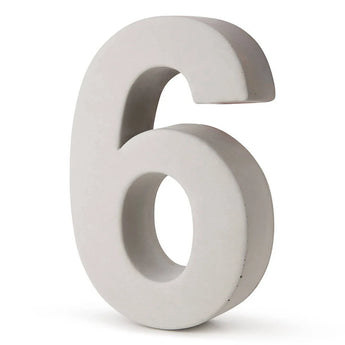 Le béton Enrico 30 cm de yessential.fr est un chiffre six tridimensionnel gris clair qui se tient debout sur un fond blanc.