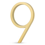 Le numéro de maison 9 Amato Gold 15 cm de yessential.fr a un design moderne de couleur dorée sur fond blanc ; parfait comme ajout élégant à votre façade.
