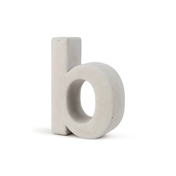 Le Enrico béton 20 cm de yessential.fr est un numéro de maison tridimensionnel en béton gris clair en forme de lettre « b », qui se tient debout sur un fond blanc.