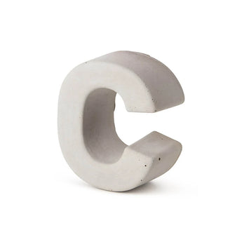 Le béton Enrico 20 cm de yessential.fr est une lettre C tridimensionnelle en béton gris clair qui se dresse sur un fond blanc uni et souligne l'apparence d'un numéro de maison élégant en béton durable.