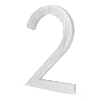 Le Milano en acier inoxydable 15 cm de yessential.fr est un numéro 2 métallique 3D avec une finition argent brossé, debout sur un fond blanc - parfait comme numéro de maison élégant et moderne pour votre maison.
