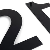 Deux numéros de maison Adamo Black 20 cm de yessential.fr, numéros 2 et 1, reposent sur un fond blanc. Le numéro 1 a une goupille de montage en haut – des numéros de façade modernes idéaux.