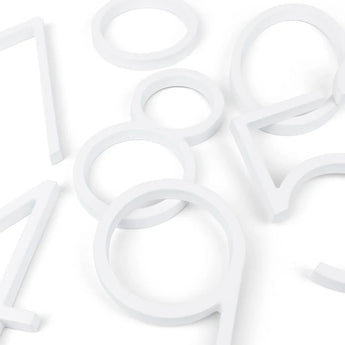 Les emporte-pièces Amato White de 12,5 cm de yessential.fr, en forme de chiffres (0, 1, 4, 5, 8 et 9), sont disposés sur un fond blanc pour un look minimaliste et moderne inspiré des numéros de maison.