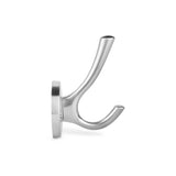 La patère Eduardo Chrome de yessential.fr, en chrome brossé avec base ronde, est montée sur fond blanc. Le crochet a deux bras arrondis, un plus long et un plus court, pointant vers le haut pour suspendre des objets.